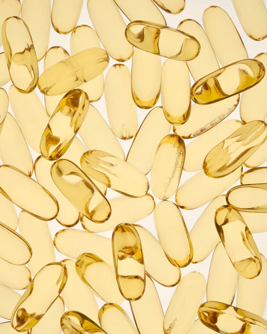 Photo of several clear, yellow, vitamin capsules