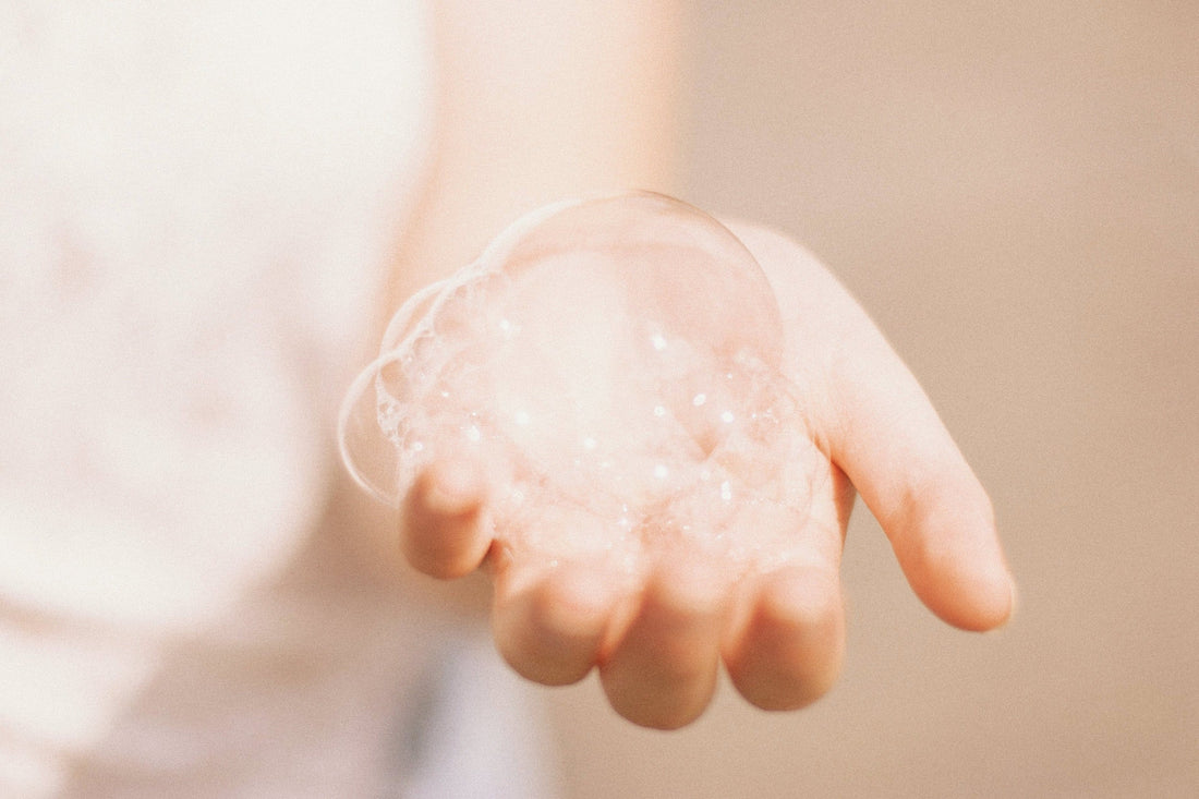 Image of a woman's hand with bubbles on her palm