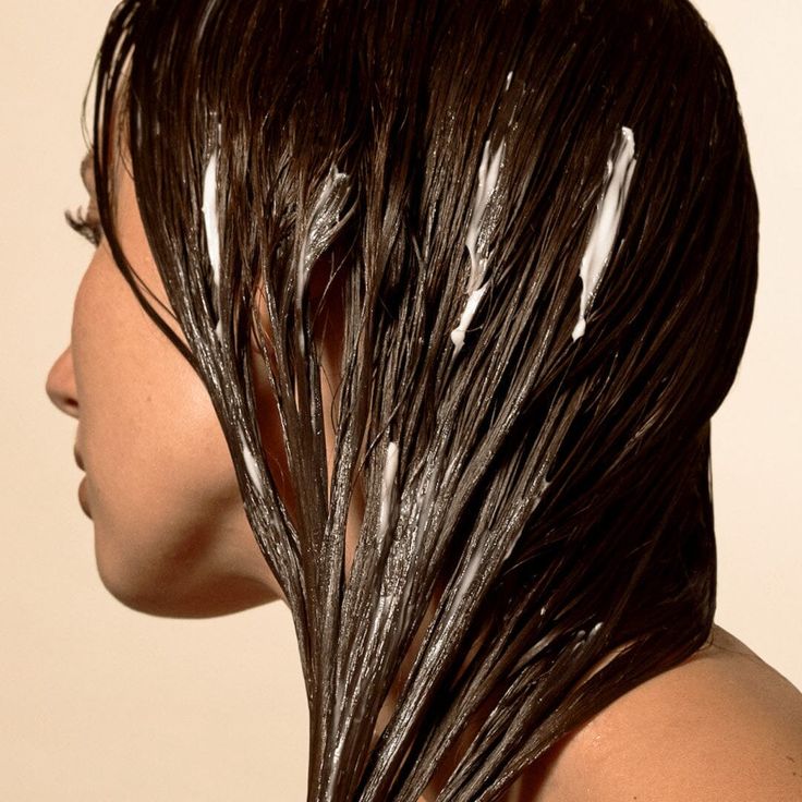 Image of a woman with conditioner on her hair