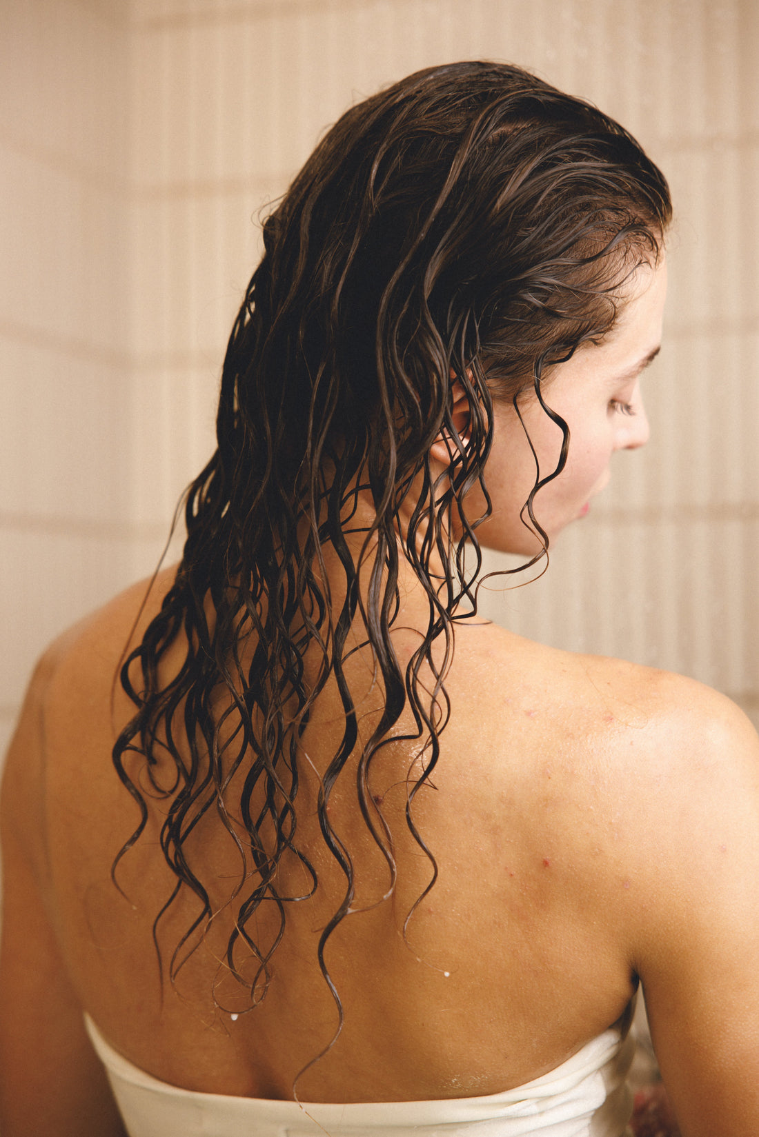Image of a woman with wet, curly hair after showering