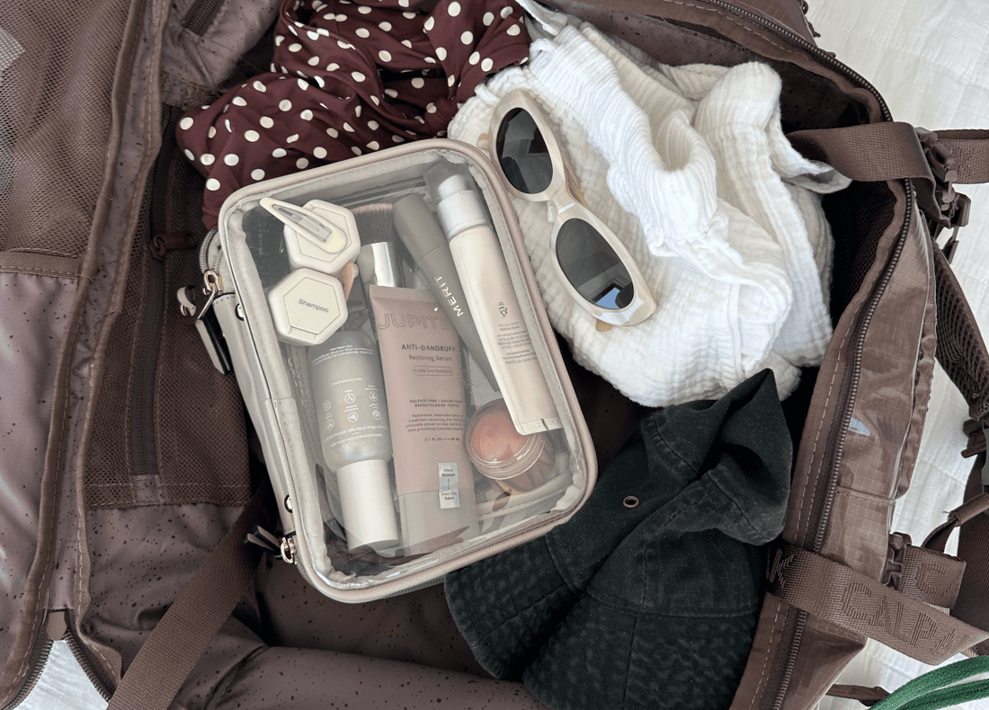 Photo of a woman's luggage showing her holiday clothes, accessories and her Jupiter Anti-dandruff Restoring Serum in a bag