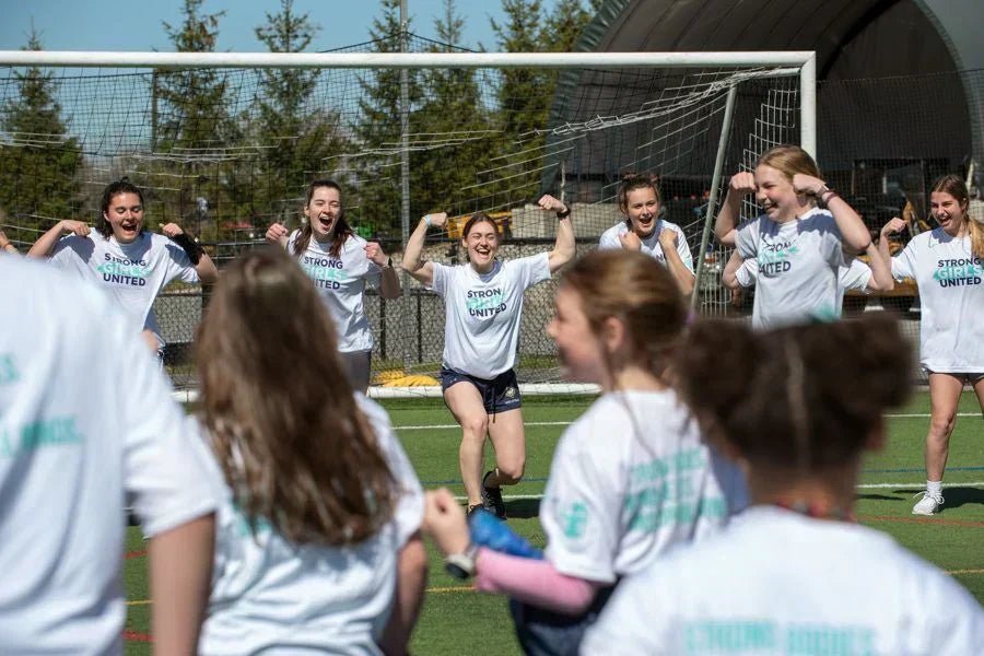 Photo of girls' soccer team celebrating on the field